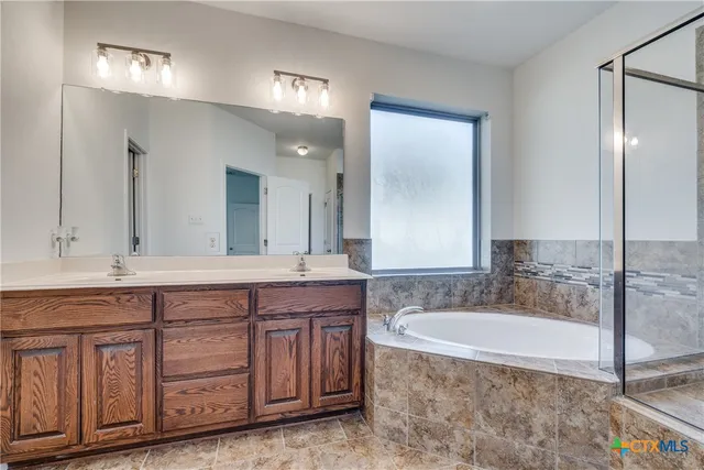a bathroom with a granite countertop double vanity sink and a mirror