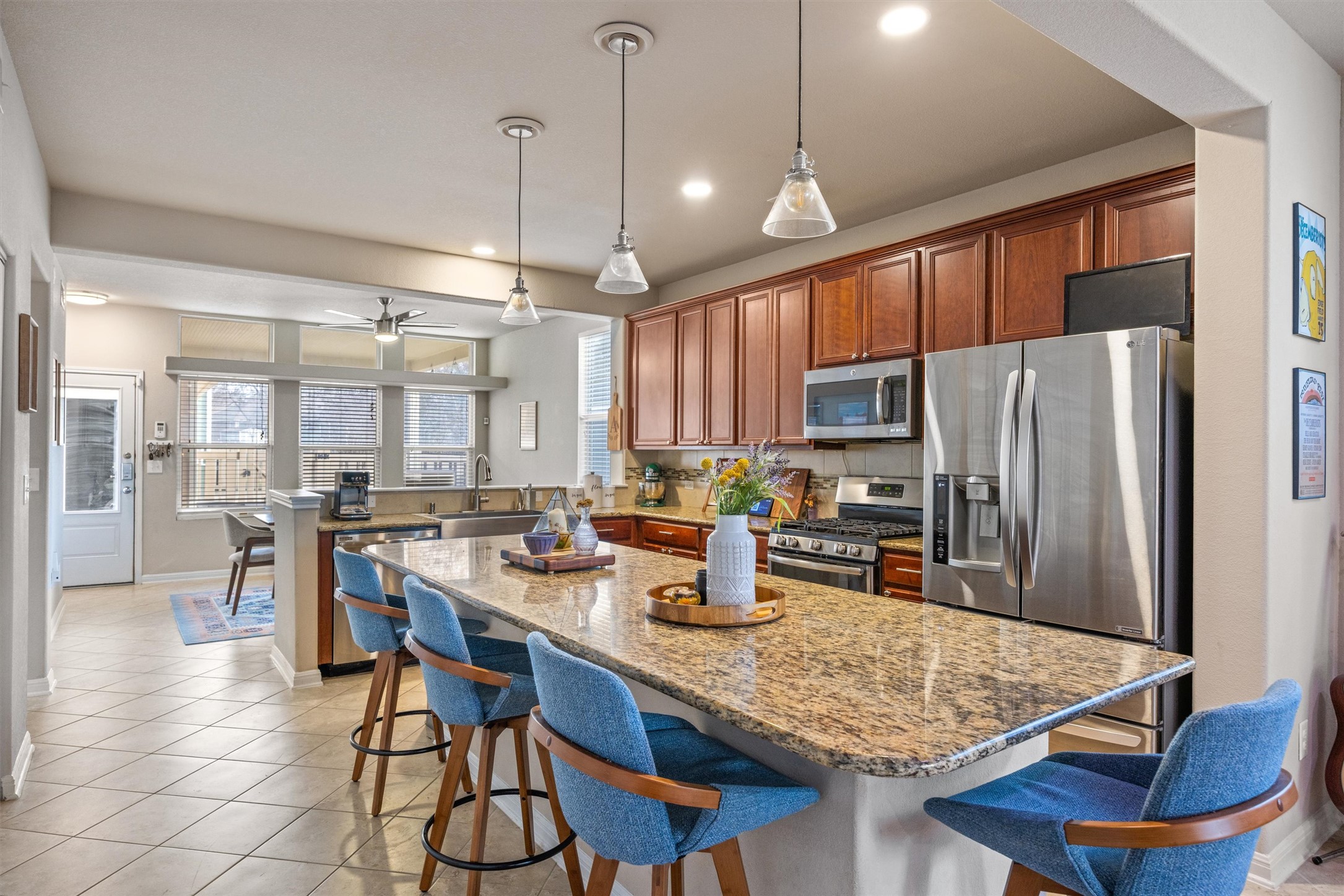 1117 Nevarez Kyle, TX 78640 - Photo 9 of 32 a kitchen with stainless steel appliances granite countertop sink refrigerator dining table and chairs