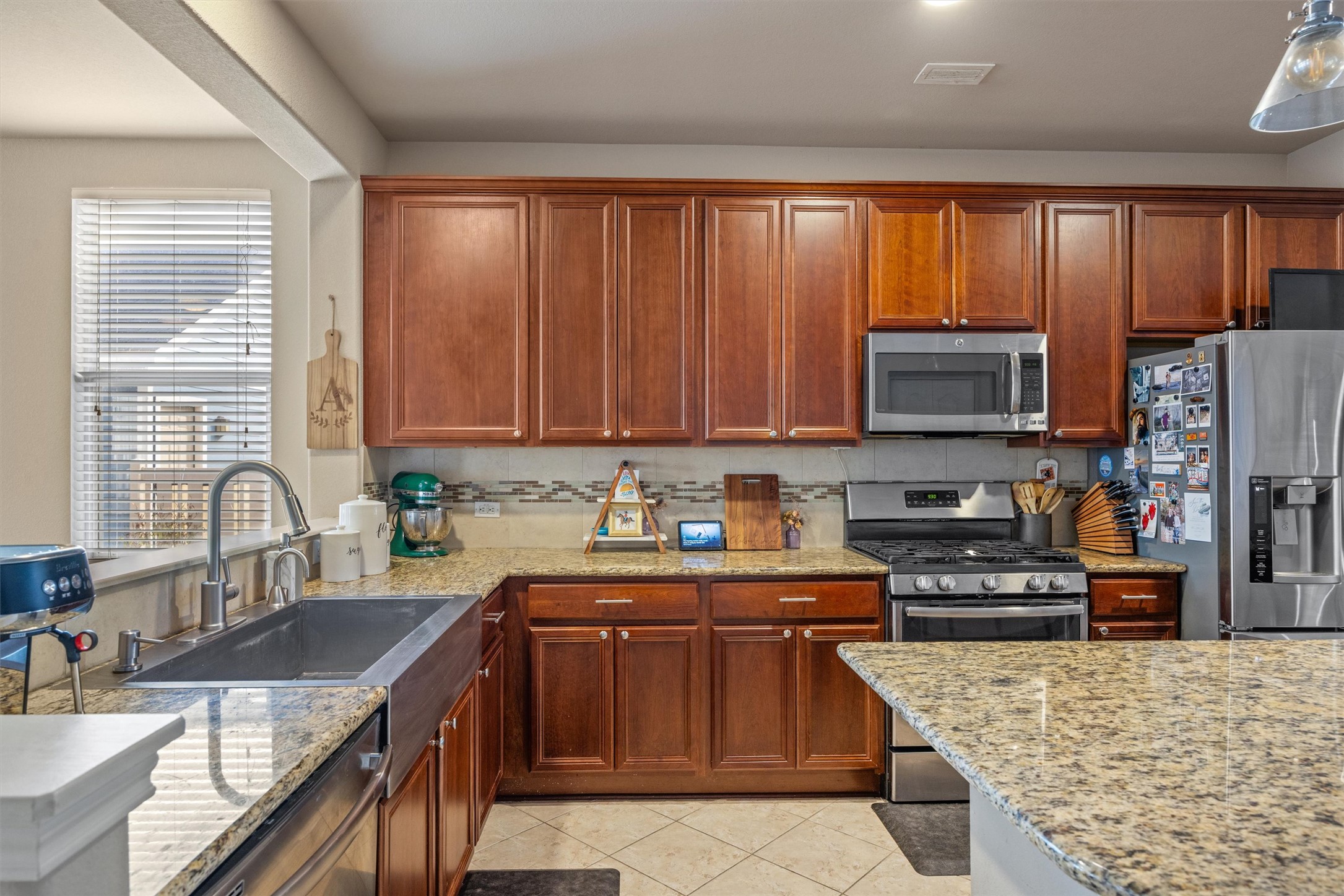1117 Nevarez Kyle, TX 78640 - Photo 10 of 32 a kitchen with stainless steel appliances granite countertop a sink stove microwave and refrigerator