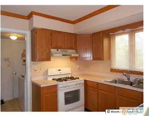 619 Lloyd Road Aberdeen, NJ 07747 - Photo 6 of 8 a kitchen with stainless steel appliances a stove a sink a refrigerator and cabinets