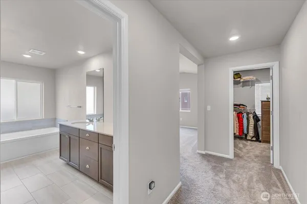 a bathroom with a tub sink and mirror