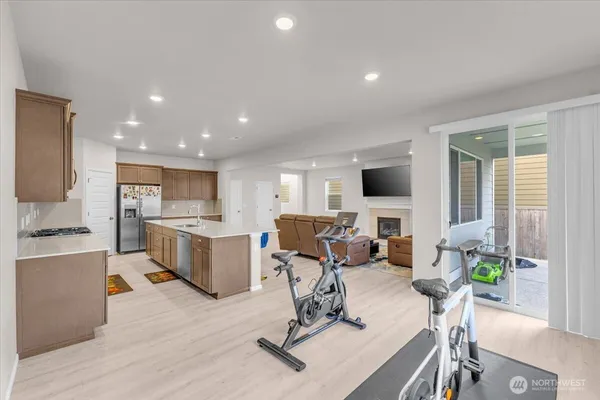 a living room with furniture a flat screen tv and kitchen view