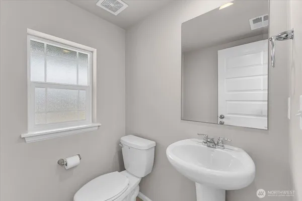 a bathroom with a sink toilet and mirror