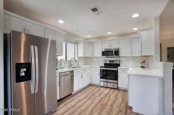 a kitchen with stainless steel appliances granite countertop a refrigerator and a window