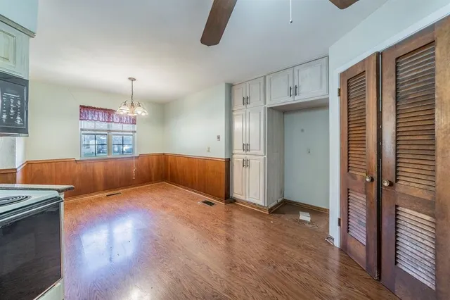 a large kitchen with granite countertop a stove a sink and a wooden floors