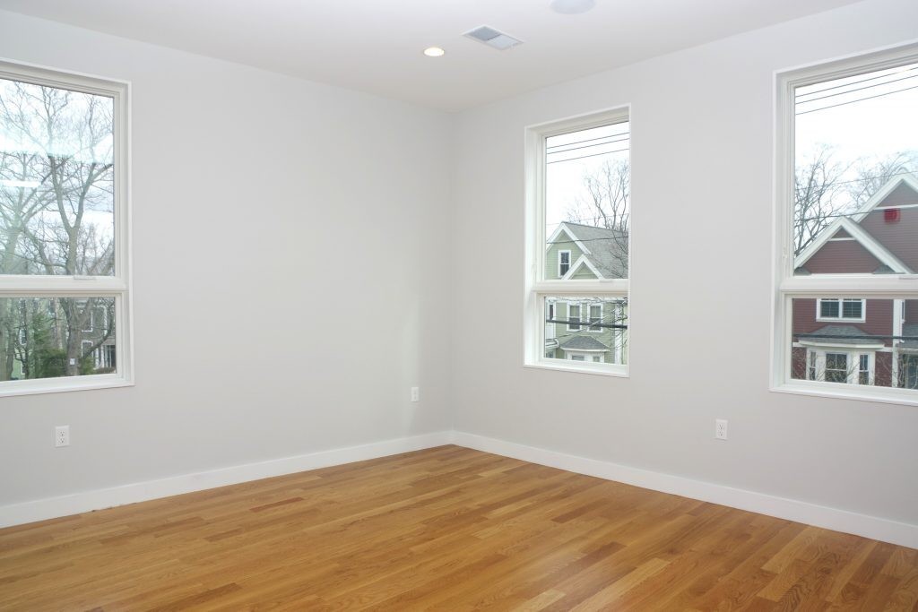 178 Thornton Street, Unit 2 Boston, MA 02119 - Photo 3 of 7 an empty room with wooden floor and windows