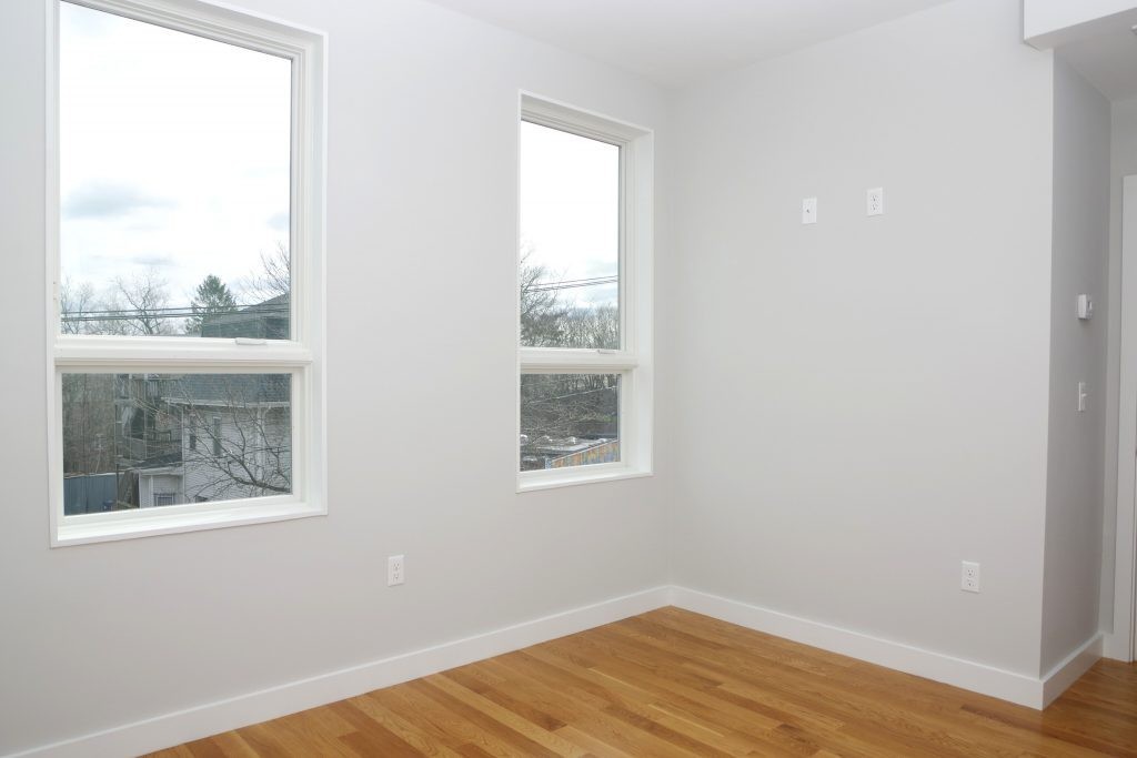 178 Thornton Street, Unit 2 Boston, MA 02119 - Photo 4 of 7 a view of an empty room with wooden floor and a window