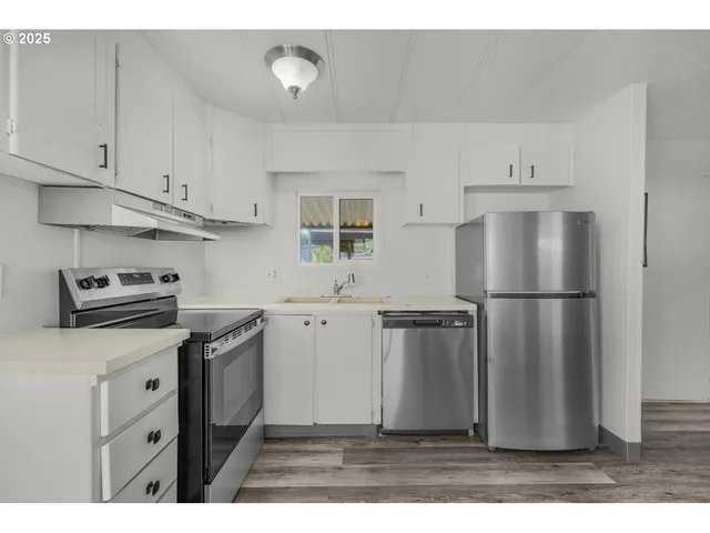 a kitchen with stainless steel appliances granite countertop a refrigerator sink and stove