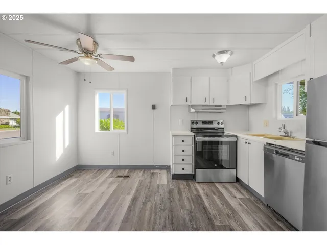 a kitchen with granite countertop a stove cabinets and wooden floor
