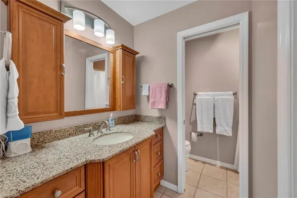 a bathroom with a granite countertop sink and a mirror