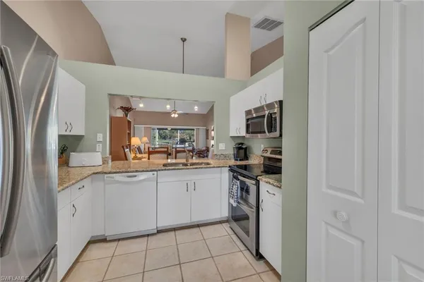 a kitchen with stainless steel appliances granite countertop a refrigerator and a stove top oven