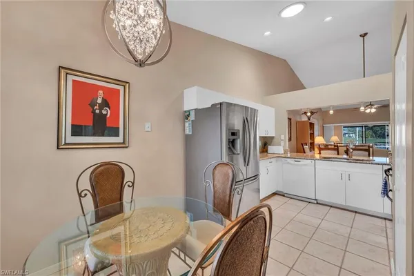a kitchen with furniture a refrigerator and dining table