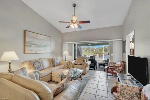 a living room with furniture a large window and a chandelier