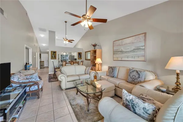 a living room with furniture a rug and a ceiling fan
