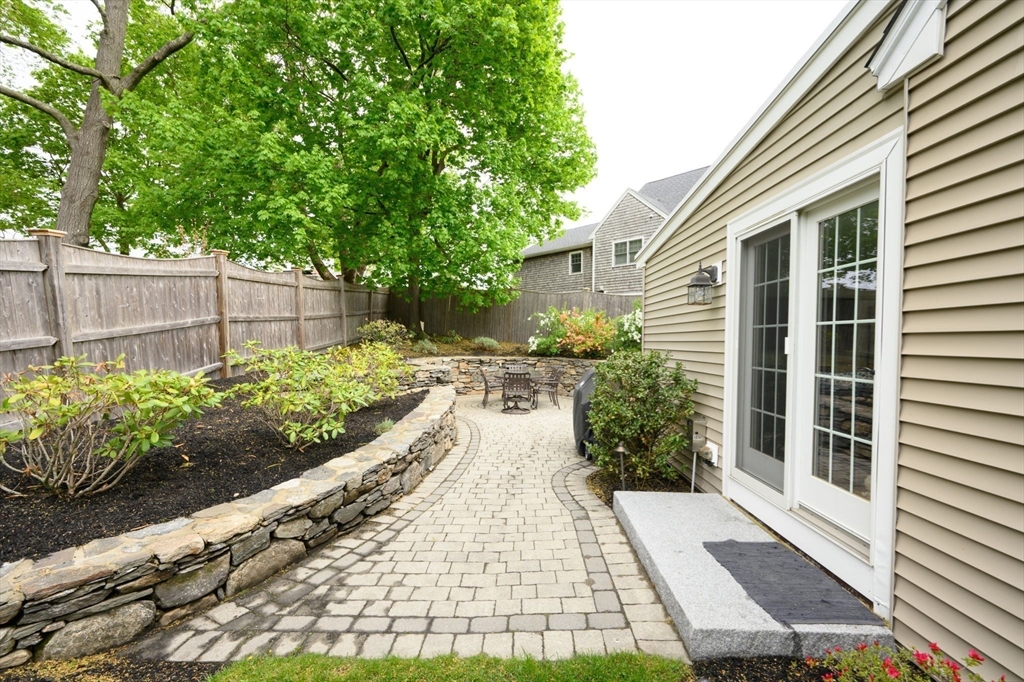21 Rice Road Hingham, MA 02043 - Photo 26 of 40 a view of a backyard with potted plants and a table and chairs