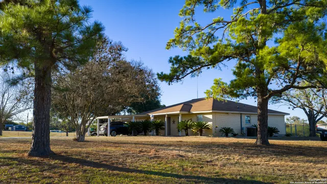 a front view of a house with a yard and trees