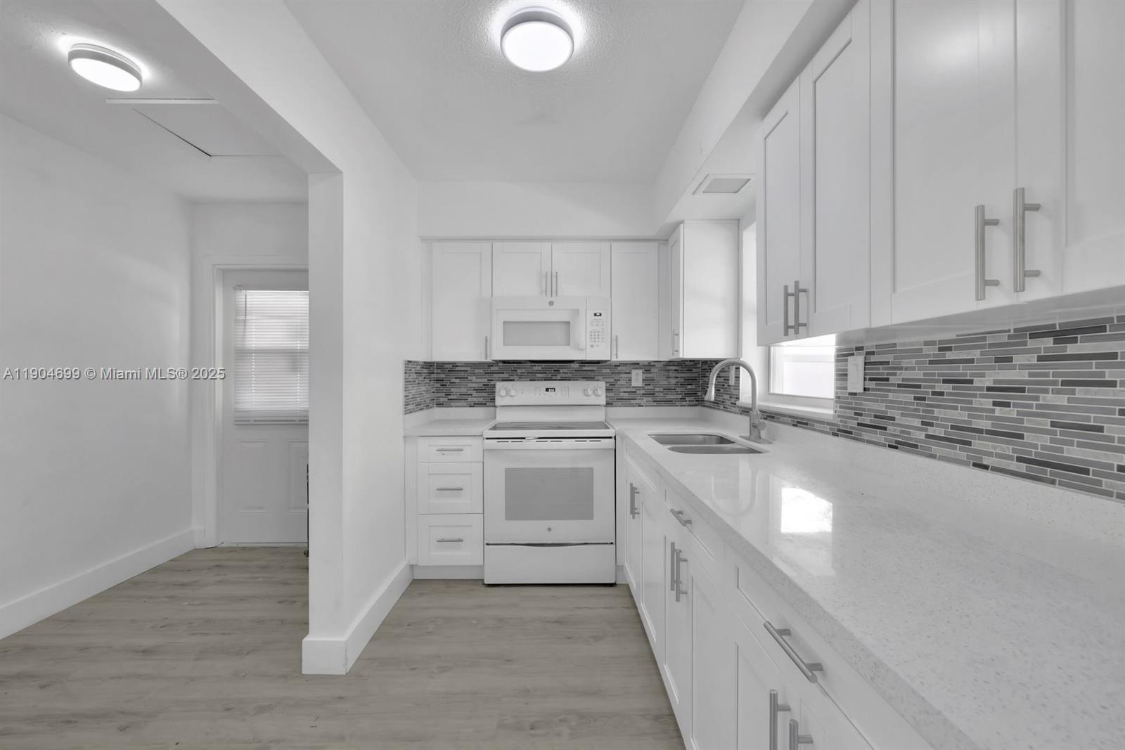 4964 Northwest 48th Way Tamarac, FL 33319 - Photo 2 of 13 a kitchen with a sink cabinets and appliances