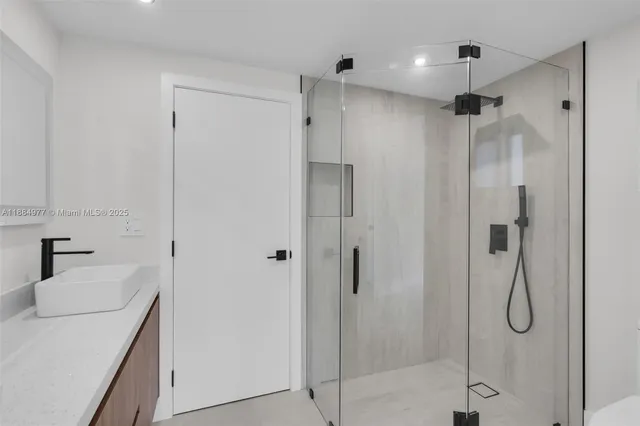 a bathroom with a shower sink vanity and mirror