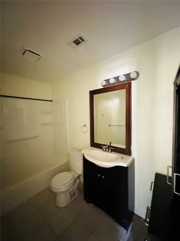 a bathroom with a toilet sink vanity and mirror