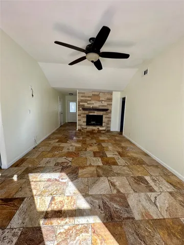 a view of empty room with wooden floor and ceiling fan
