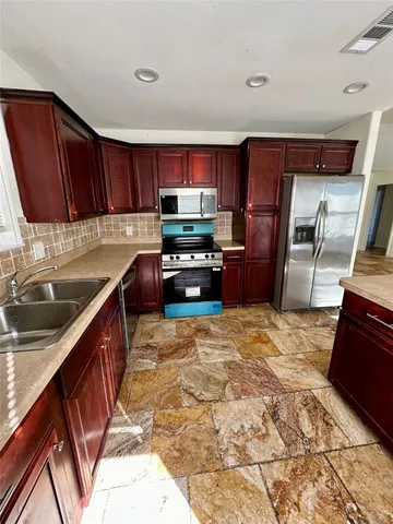 a kitchen with granite countertop a refrigerator and a sink