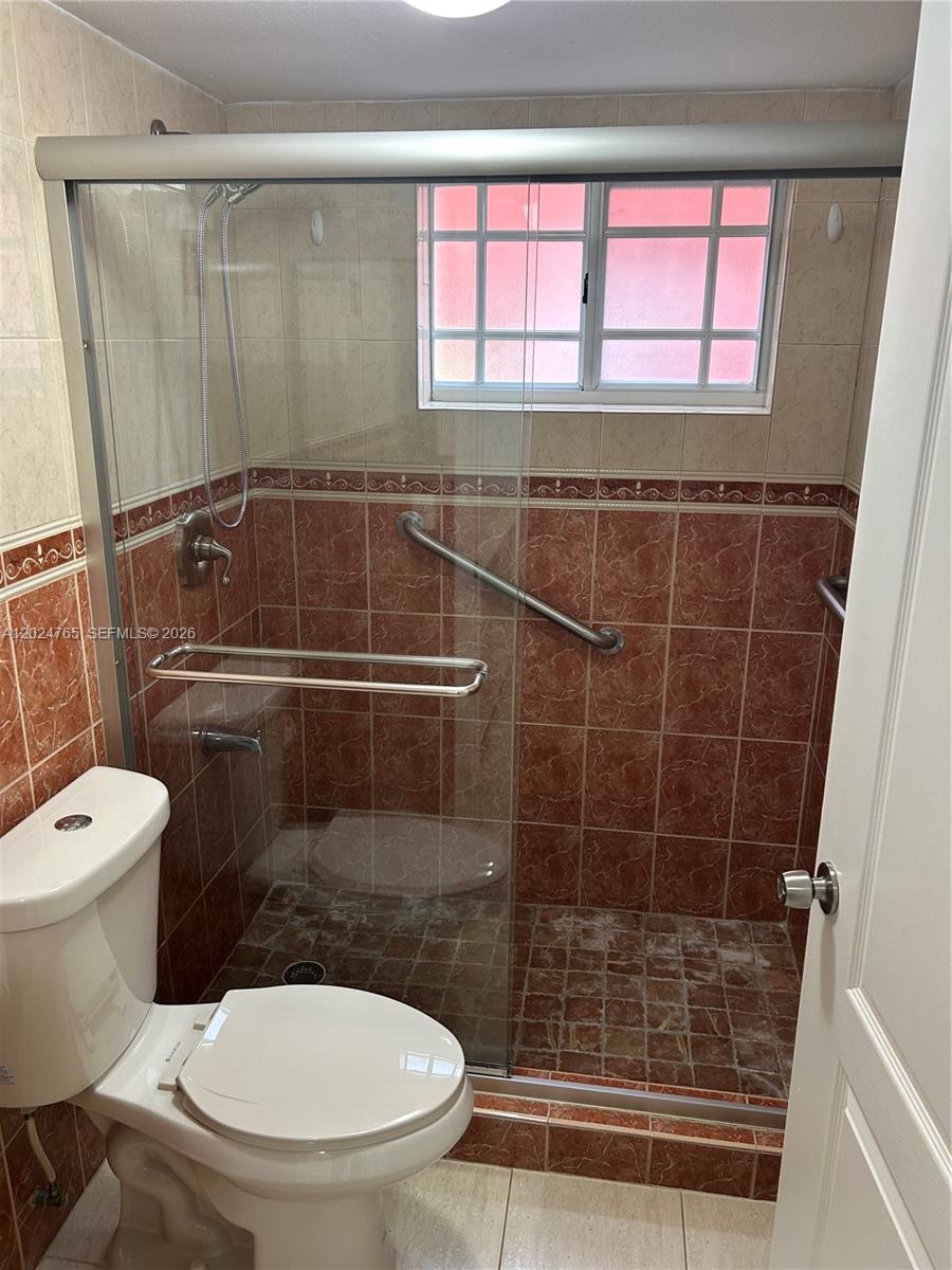 10919 West Okeechobee Road, Unit 101 Hialeah Gardens, FL 33018 - Photo 6 of 21 a bathroom with a toilet and a shower