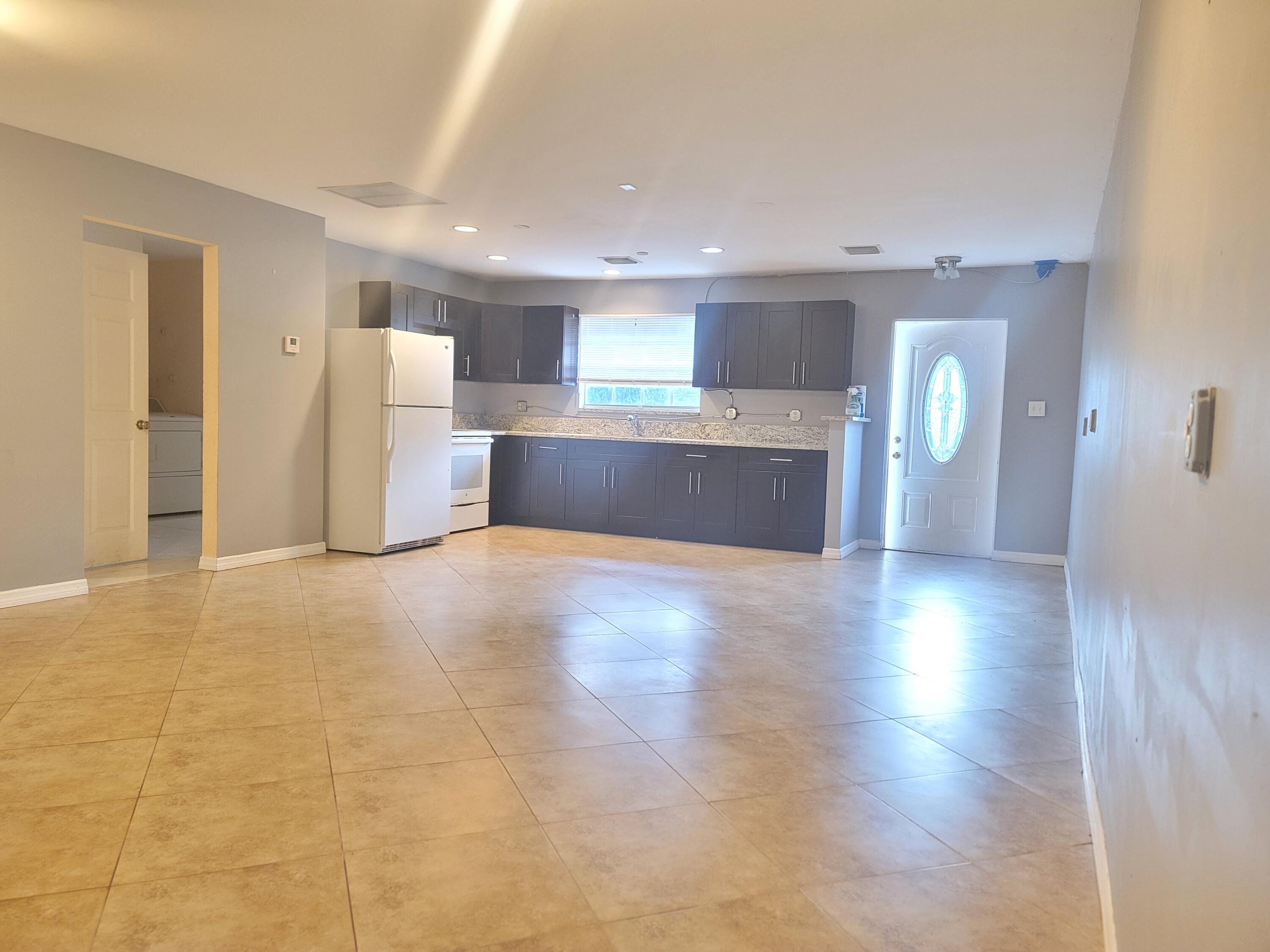 15664 N Road, Unit A Loxahatchee Groves, FL 33470 - Photo 9 of 16 a view of a kitchen with a sink and a refrigerator