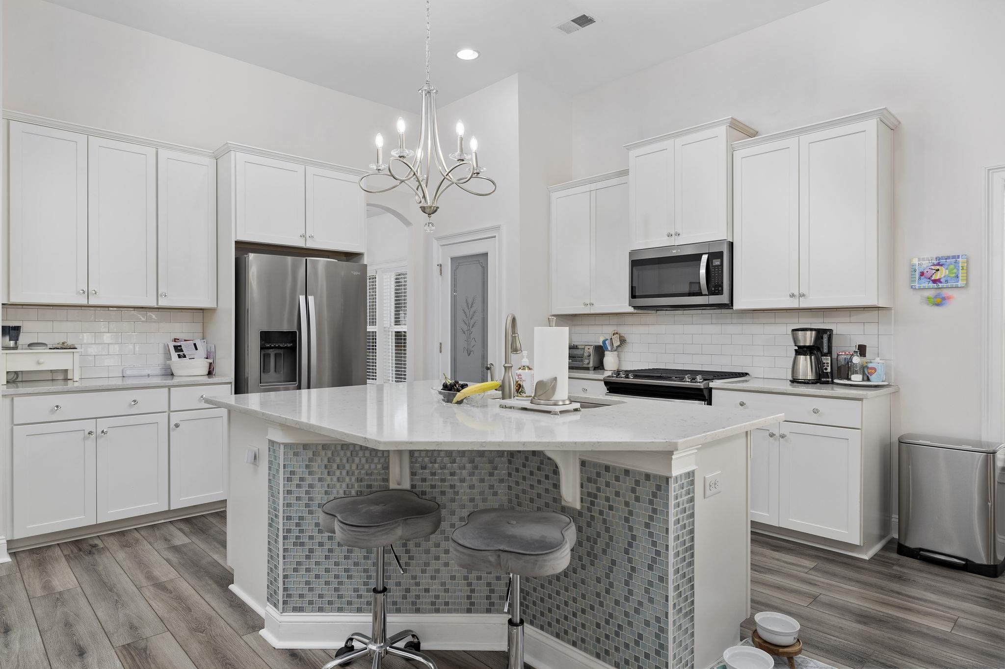 1704 Edgewood Drive Myrtle Beach, SC 29577 - Photo 11 of 40 Kitchen featuring a kitchen breakfast bar, stainless steel appliances, white cabinetry, backsplash, and recessed lighting