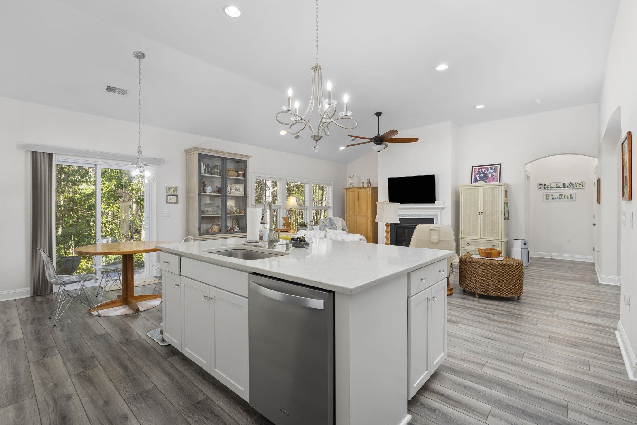 1704 Edgewood Drive Myrtle Beach, SC 29577 - Photo 13 of 40 Kitchen with stainless steel dishwasher, vaulted ceiling, light stone countertops, a kitchen island with sink, and arched walkways