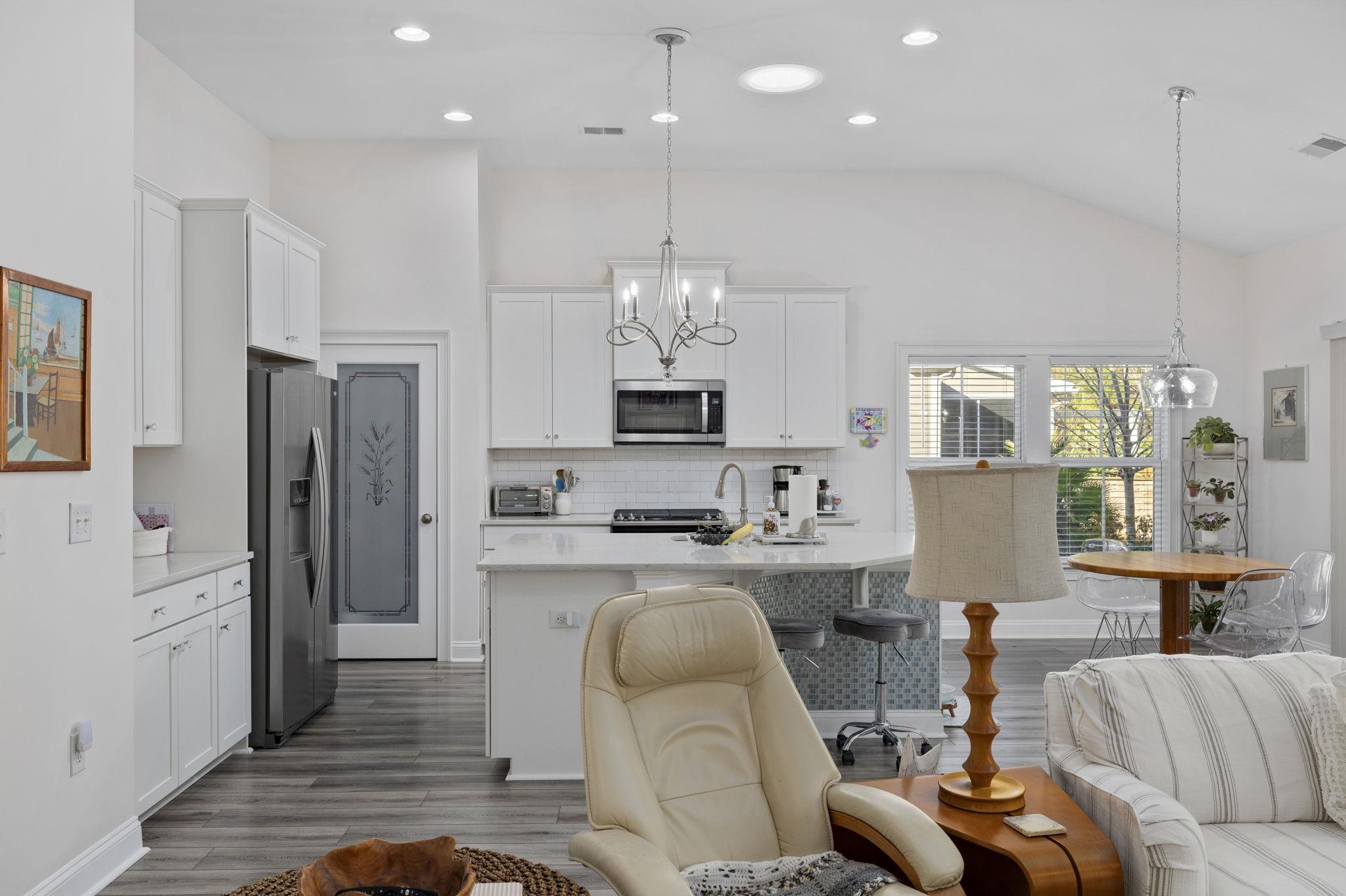 1704 Edgewood Drive Myrtle Beach, SC 29577 - Photo 39 of 40 Kitchen with a chandelier, white cabinets, stainless steel appliances, open floor plan, and vaulted ceiling