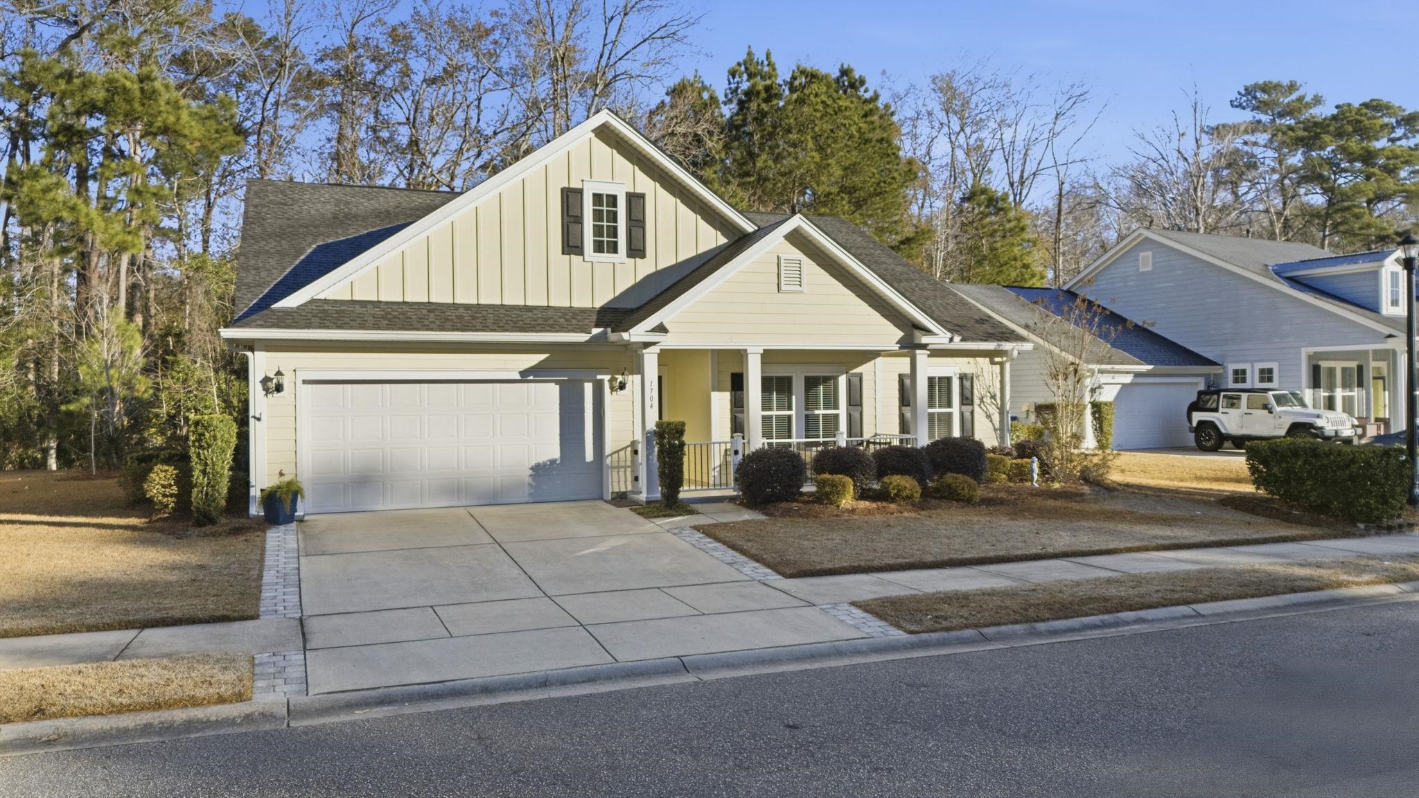 1704 Edgewood Drive Myrtle Beach, SC 29577 - Photo 2 of 40 View of front of house with board and batten siding, a porch, a shingled roof, driveway, and a garage