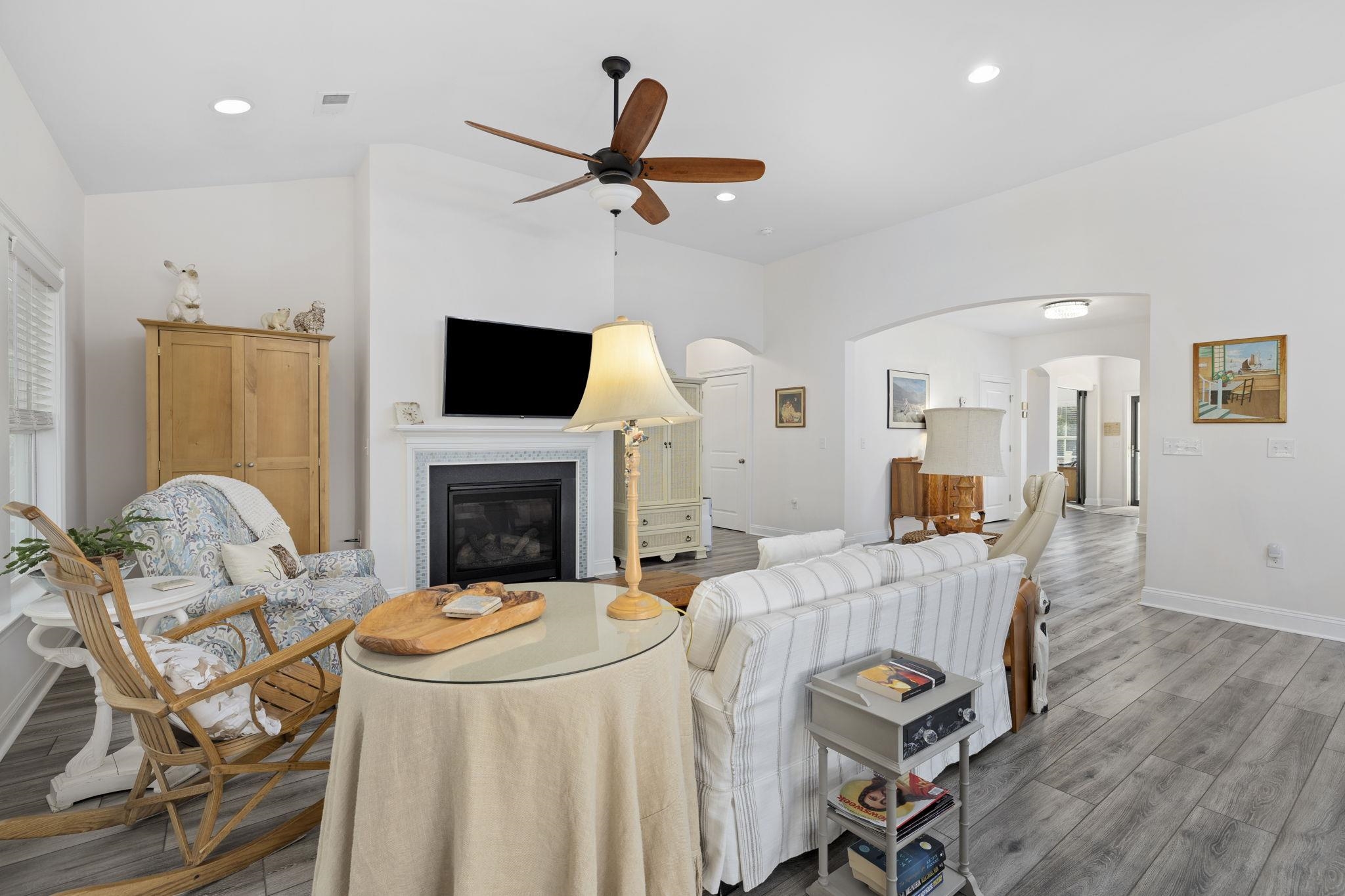 1704 Edgewood Drive Myrtle Beach, SC 29577 - Photo 8 of 40 Living area with a glass covered fireplace, light wood-style floors, a ceiling fan, arched walkways, and recessed lighting