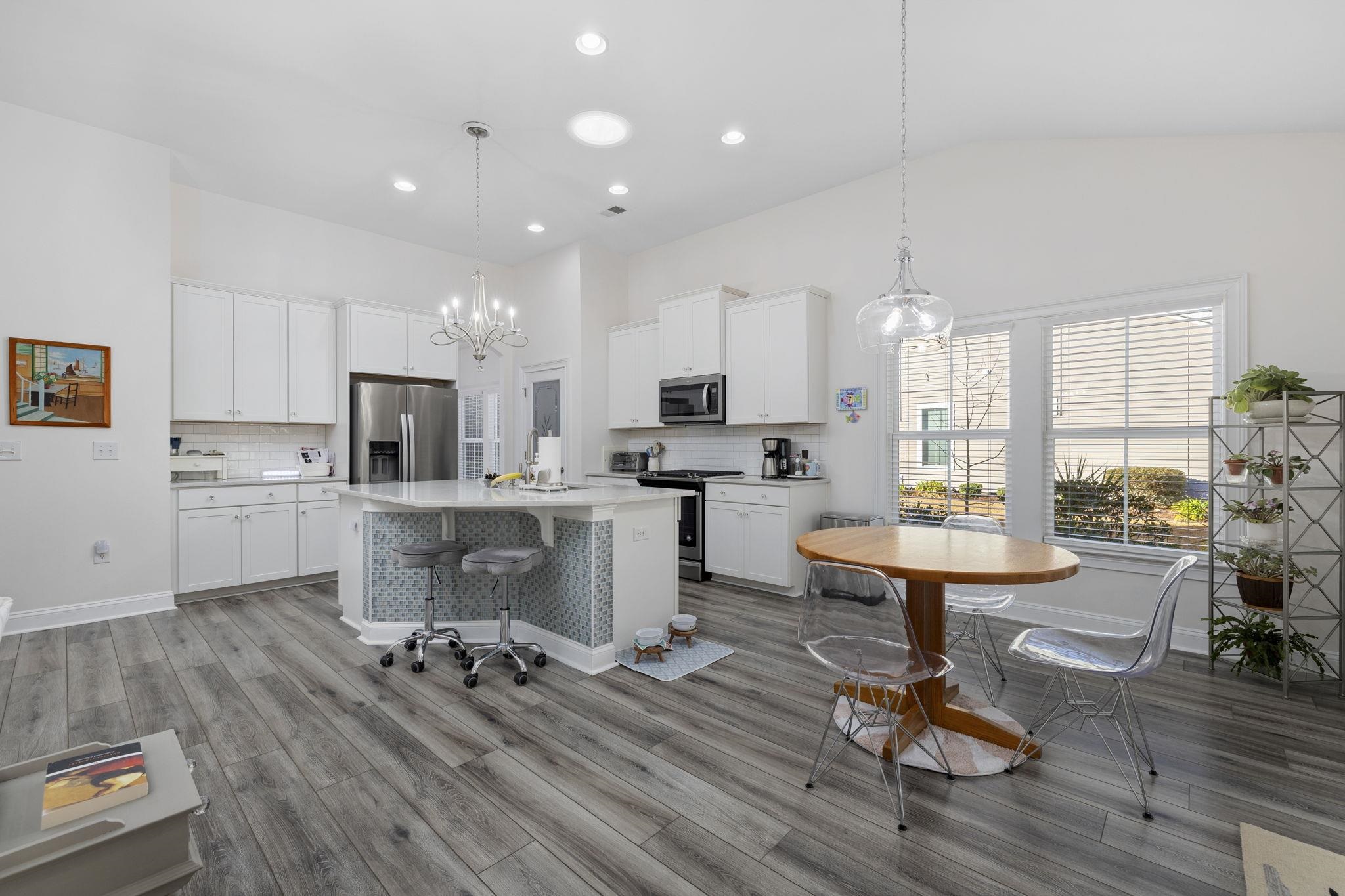 1704 Edgewood Drive Myrtle Beach, SC 29577 - Photo 9 of 40 Kitchen with a breakfast bar, white cabinets, stainless steel appliances, a chandelier, and hanging light fixtures