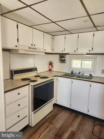 a kitchen with stainless steel appliances granite countertop a sink a stove and cabinets