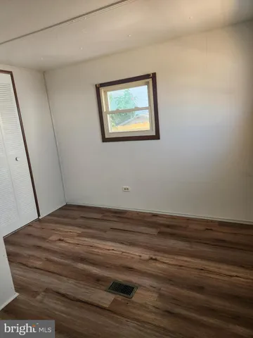 a view of a room with wooden floor and window