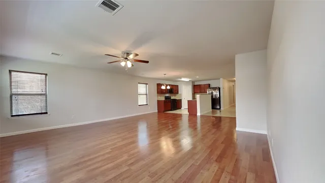 a view of a livingroom with wooden floor and a ceiling fan