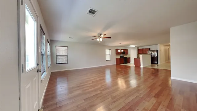 a view of empty room with wooden floor