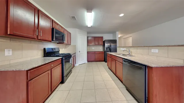a kitchen with stainless steel appliances granite countertop a sink counter space cabinets and a large window