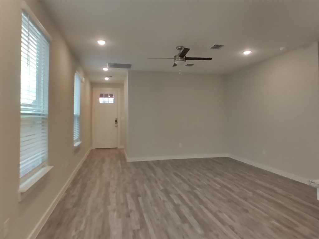 609 Foxtail Agave Street Leander, TX 78641 - Photo 2 of 29 wooden floor in an empty room with a window