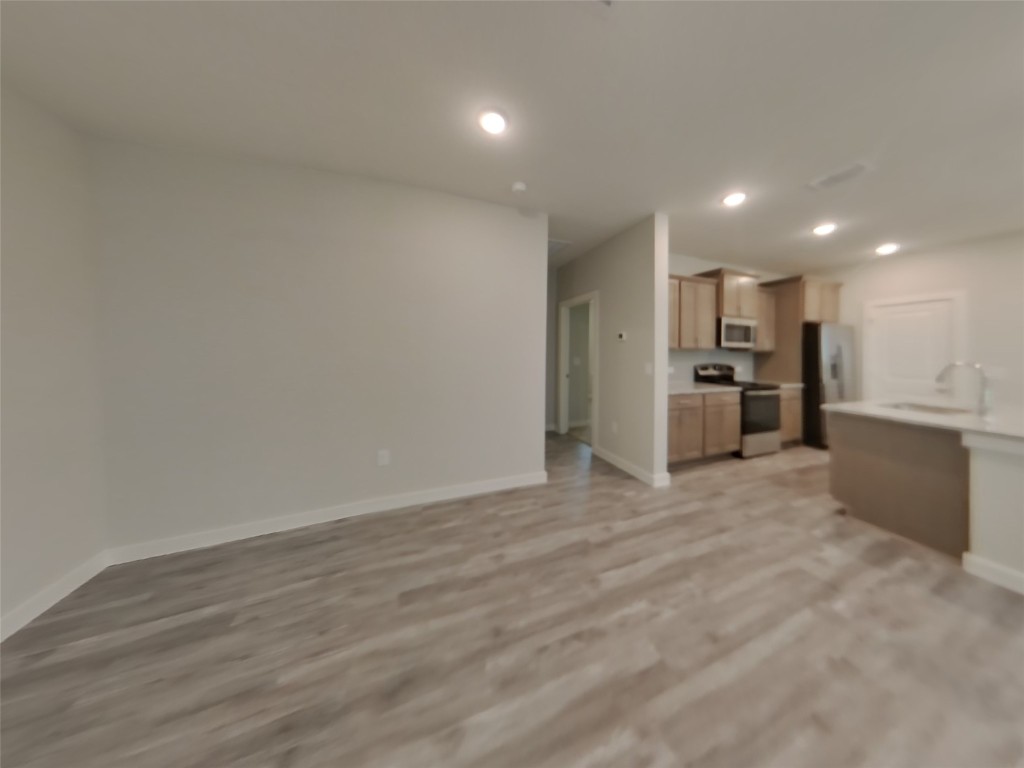 609 Foxtail Agave Street Leander, TX 78641 - Photo 3 of 29 a view of a kitchen with a refrigerator and a microwave