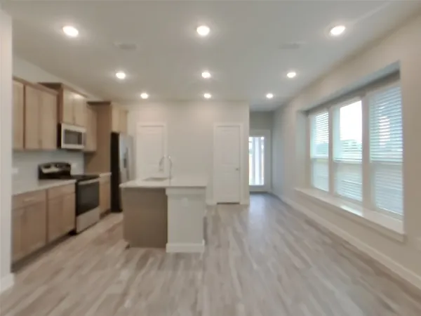 a view of kitchen with sink and refrigerator