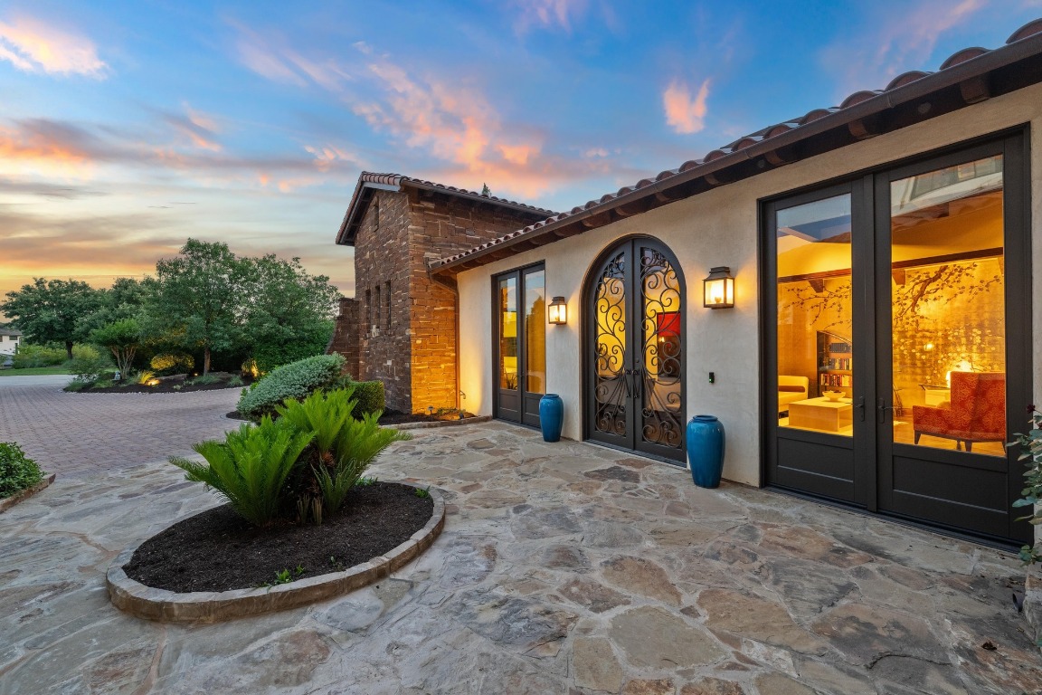 12724 Little Blue Austin, TX 78738 - Photo 8 of 40 a view of a house with large windows and a yard