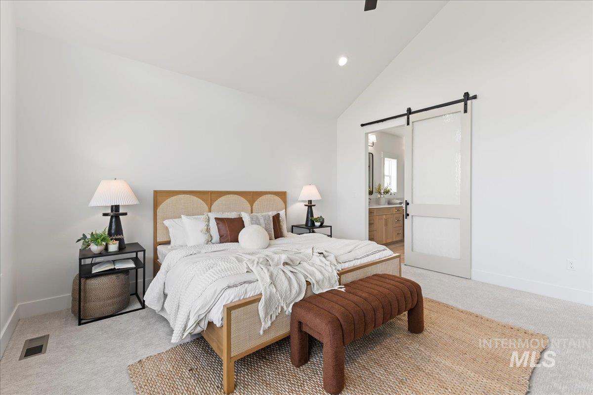 9580 South Prairie Falcon Avenue Nampa, ID 83686 - Photo 25 of 50 Bedroom with carpet flooring, a barn door, high vaulted ceiling, ensuite bath, and ceiling fan