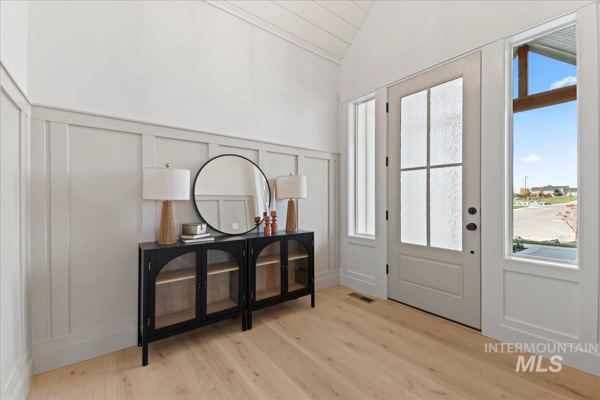 9580 South Prairie Falcon Avenue Nampa, ID 83686 - Photo 7 of 50 Entrance foyer featuring a decorative wall, vaulted ceiling, light wood-style floors, and a wainscoted wall