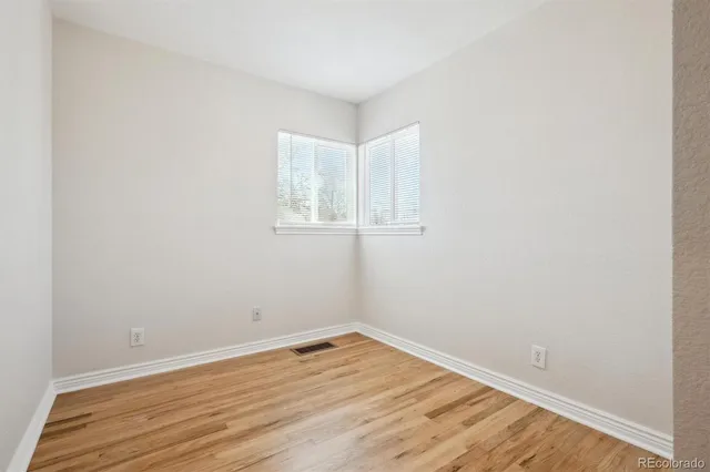 a view of empty room with wooden floor