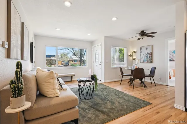a living room with furniture two window and a table