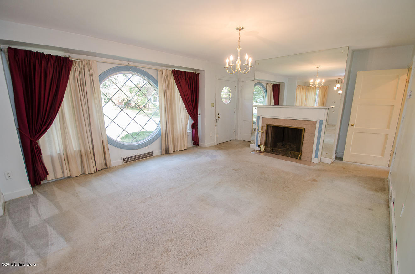 Large living room offers more than ample natural light and a fireplace surrounded by mirrors.