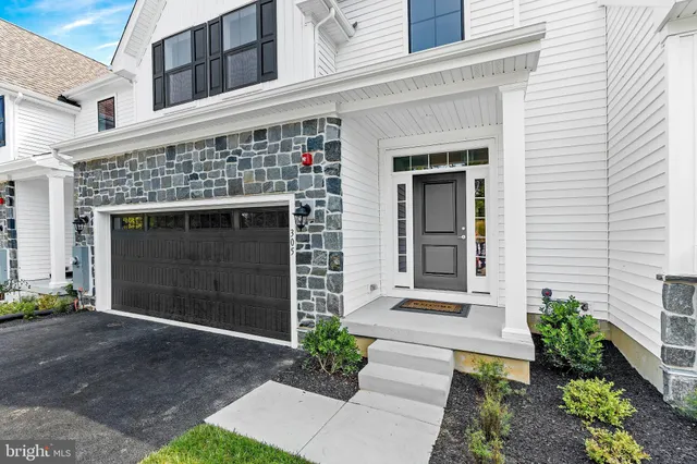 a front view of a house with a garden and garage