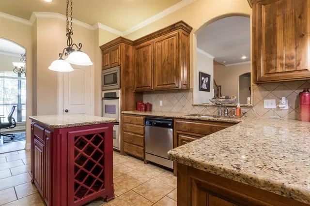 a kitchen with stainless steel appliances granite countertop a sink a stove and a wooden cabinets