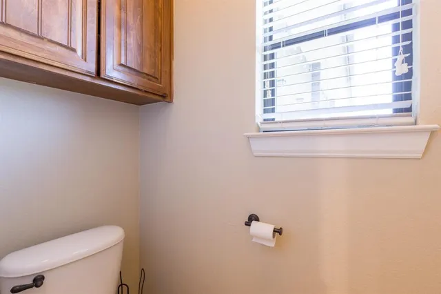 a bathroom with a toilet a sink and a window